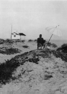 Il pittore Llewellyn Lloyd (1879 - 1949) mentre dipinge il quadro della capannina degli Olschki sulla spiaggia.